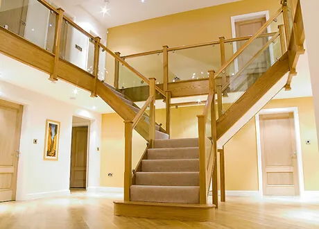 Bespoke oak and glass staircase in a residential hallway