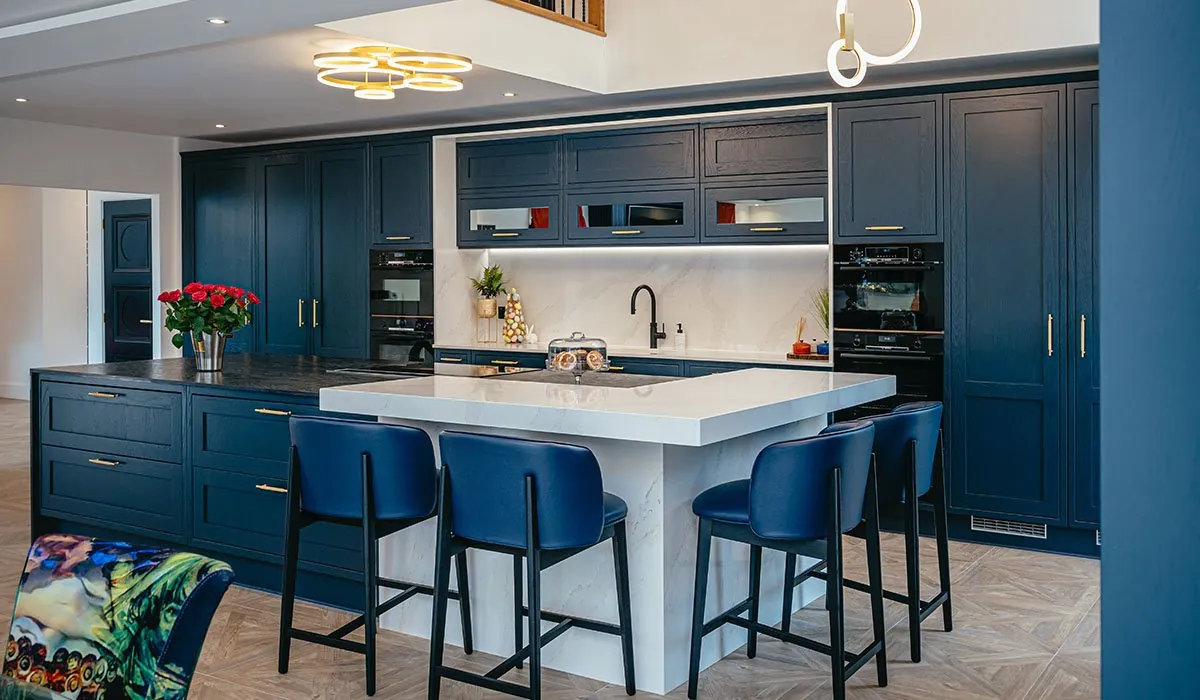 Navy fitted kitchen with white worktops and skylight